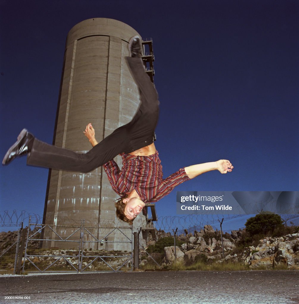 South Africa, near Cape Town, young man doing backflip in mid air