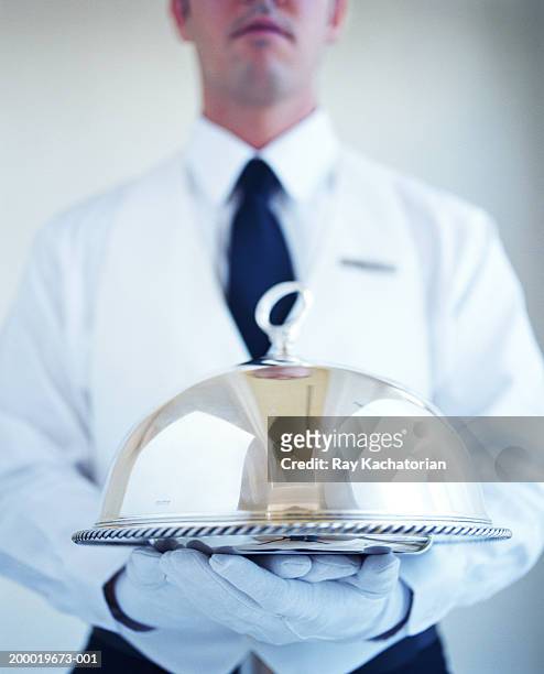 waiter wearing white gloves, carrying silver platter - zilverkleurige handschoen stockfoto's en -beelden