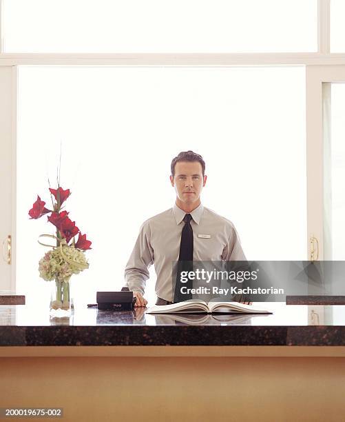 hotel clerk at front desk, guest book on counter - pre reception stockfoto's en -beelden