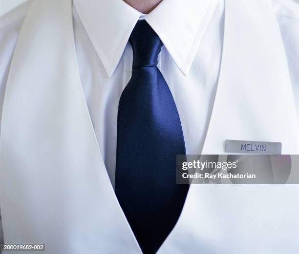 man wearing white shirt and blue tie with name tag - uniform name tag stockfoto's en -beelden