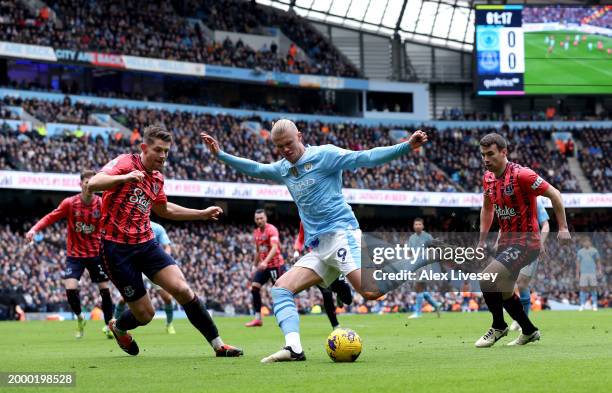 Erling Haaland of Manchester City is challenged by James Tarkowski and Seamus Coleman of Everton during the Premier League match between Manchester...