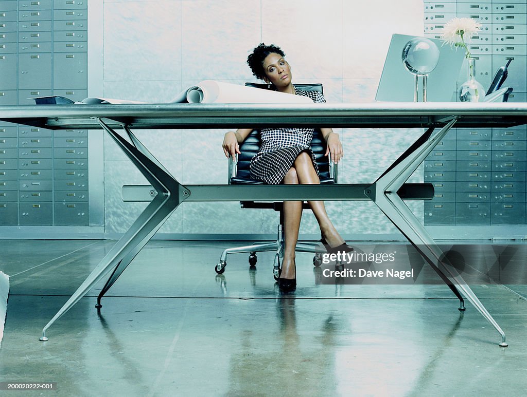 Businesswoman sitting behind desk, portrait