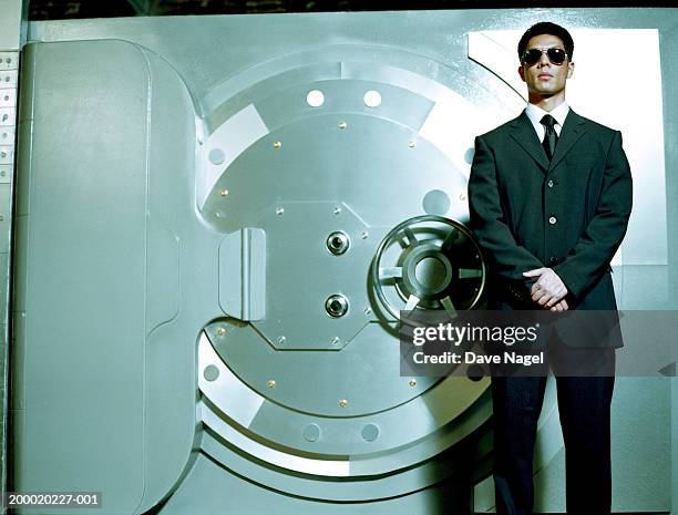 man wearing sunglasses in front of vault - bank vault stock pictures, royalty-free photos & images