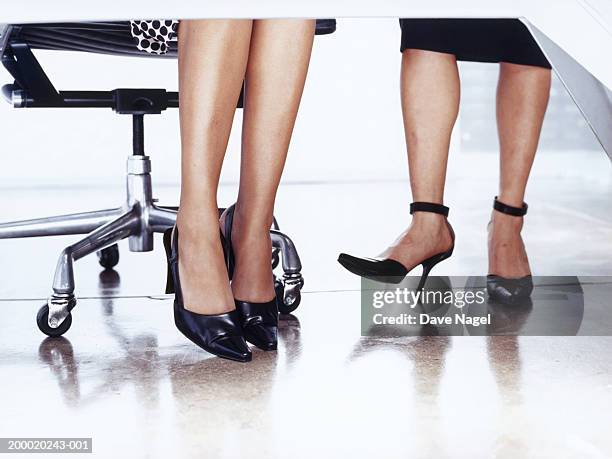 businesswomen at desk, low section - höga klackar bildbanksfoton och bilder