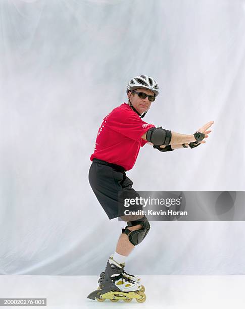 man wearing inline skates, helmet and safety pads - coudière photos et images de collection