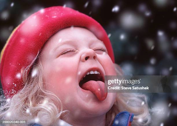 girl (4-6) catching snow flakes on tongue, close-up - blonde girl sticking out her tongue stock pictures, royalty-free photos & images