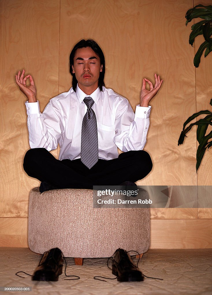 Young businessman meditating