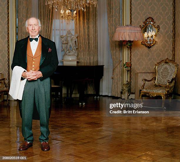 elderly butler standing in room, portrait - butler stock pictures, royalty-free photos & images