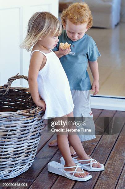 girl and boy (2-4) on porch, girl wearing adult's sandals - barefoot redhead ストックフォトと画像
