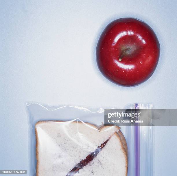 red apple beside peanut butter and jelly sandwich in plastic bag - food bag stock pictures, royalty-free photos & images