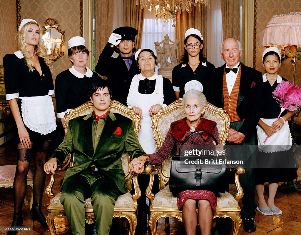 Elderly woman and young man with domestic staff, portrait