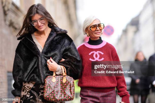 Guest wears glasses, a dark brown fluffy oversized jacket, a Vuitton brown leather monogram logo printed bag with printed cherries, a mini skirt ,...