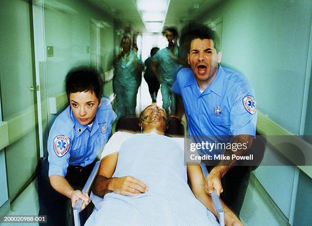 emergency medical technician wheeling in patient on stretcher - hospital gurney stock pictures, royalty-free photos & images