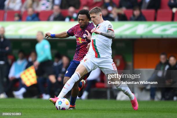 Kristijan Jakic of FC Augsburg is challenged by Lois Openda of RB Leipzig during the Bundesliga match between FC Augsburg and RB Leipzig at WWK-Arena...