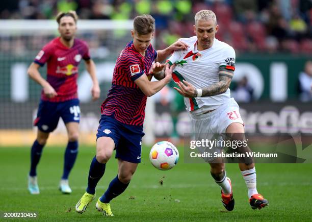 Dani Olmo of RB Leipzig battles for possession with Philip Tietz of FC Augsburg during the Bundesliga match between FC Augsburg and RB Leipzig at...