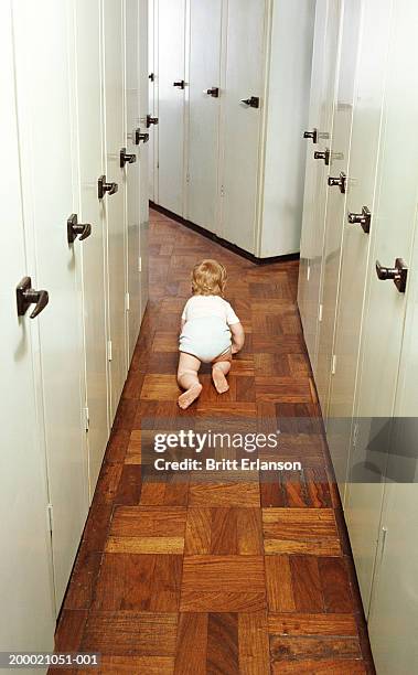 female toddler (18-21 months) crawling along corridor, rear view - one baby girl only fotografías e imágenes de stock