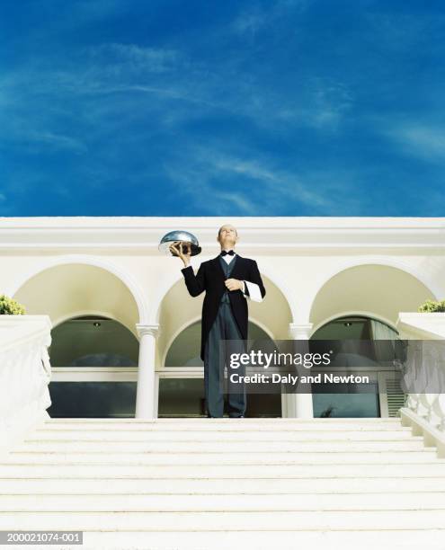 butler holding silver tray at top of steps outdoors - cloche stock pictures, royalty-free photos & images