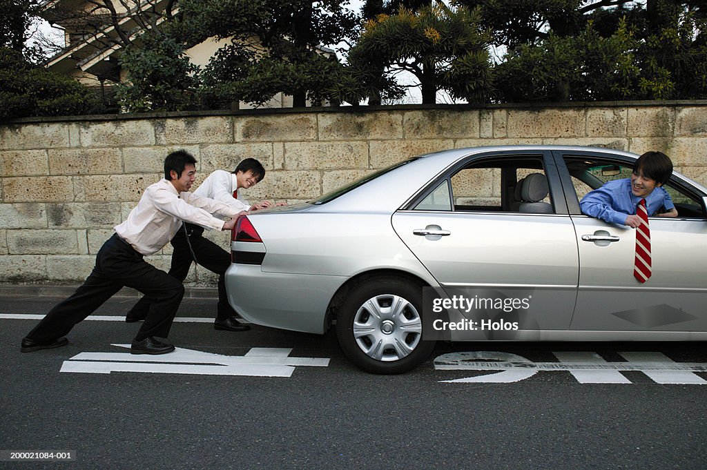 Two Businessmen pushing car