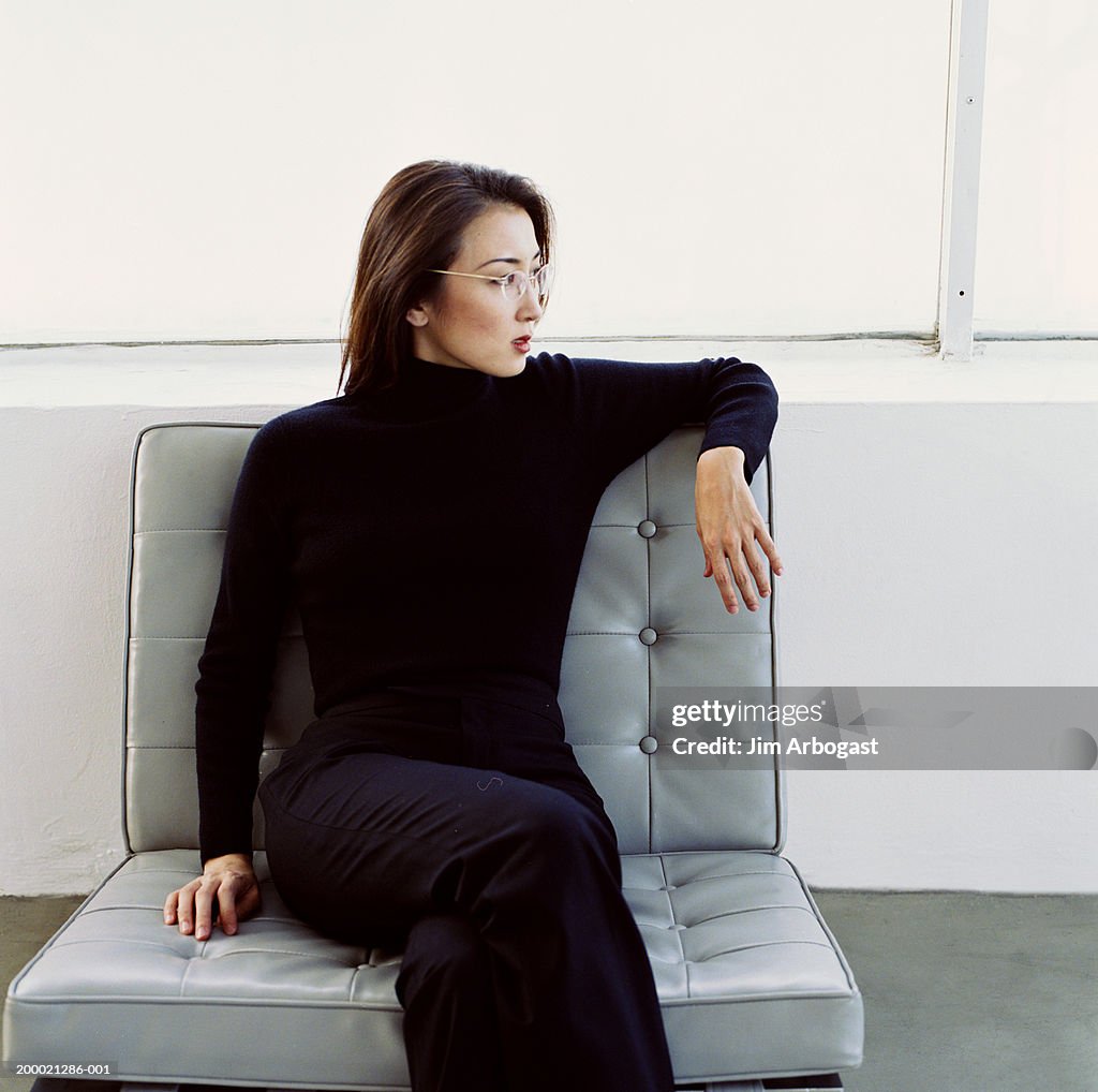 Woman sitting on gray-cushioned chair