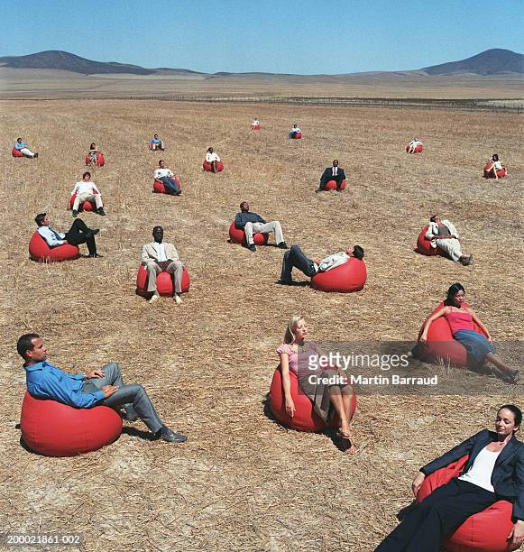 group of people on red bean bags in open landscape - bean bags fotografías e imágenes de stock