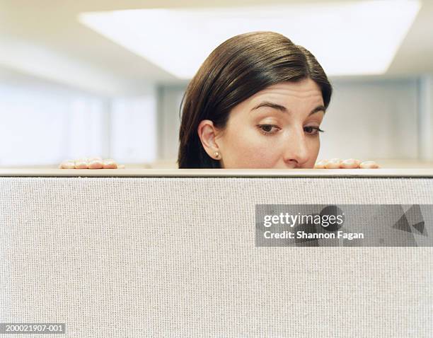 businesswoman looking over partition, close-up - spähen stock-fotos und bilder