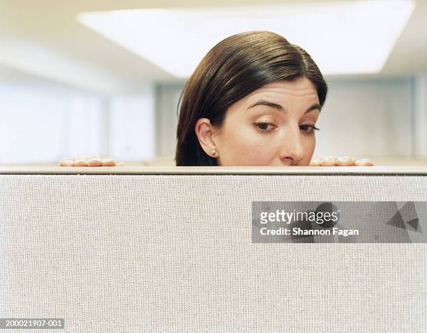 businesswoman looking over partition, close-up - peek fotografías e imágenes de stock