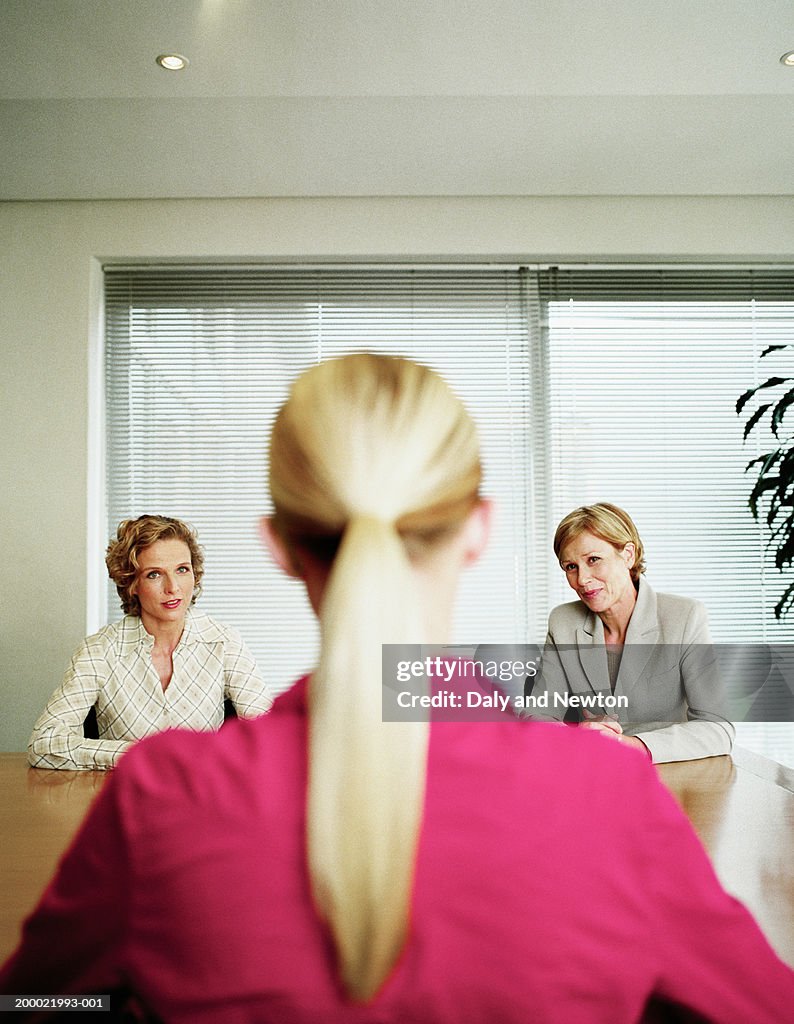 Three businesswomen in discussion (focus on women in background)