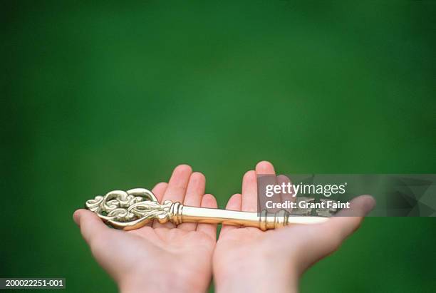 boy (4-6) holding skeleton key, close-up, rear view - golden boy stock pictures, royalty-free photos & images