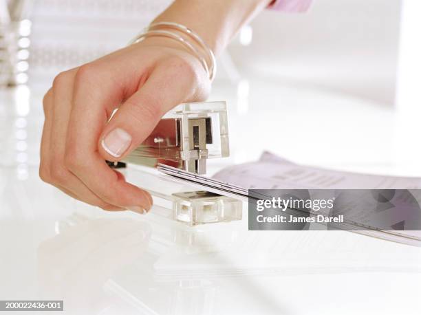 woman using stapler, close-up - tacler stock-fotos und bilder