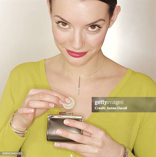 woman taking coin out of purse, portrait - silver purse stock pictures, royalty-free photos & images