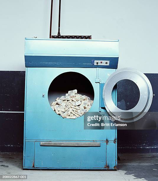 wads of bank notes in industrial washing machine - money laundering fotografías e imágenes de stock