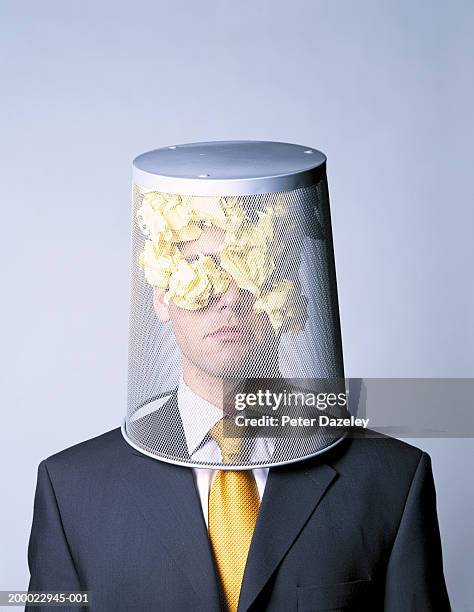 businessman with wastepaper basket on head, portrait - anti bullying stockfoto's en -beelden