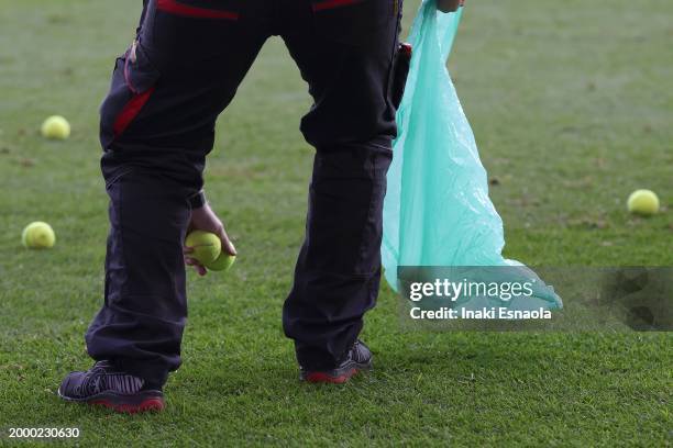 Crew member picks up tennis balls that 1. FC Union Berlin supporters threw to the court in protest against the DFL during the Bundesliga match...