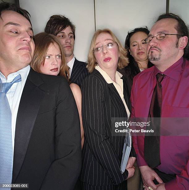 group of business people in lift, close-up - moue de dédain photos et images de collection