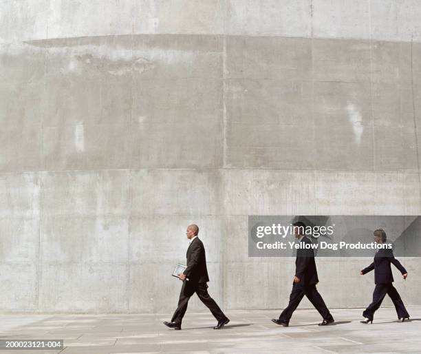 group of businesspeople walking through plaza - gray suit stock pictures, royalty-free photos & images