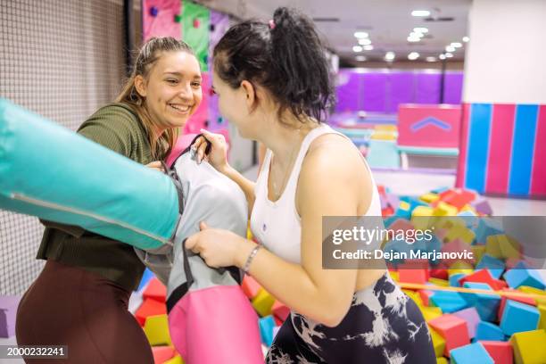 female friends having fun in indoor playground - playground balance beam stock pictures, royalty-free photos & images