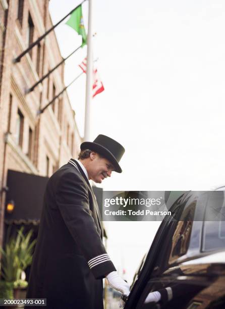 hotel doorman opening car door, low angle view - doorman stock pictures, royalty-free photos & images