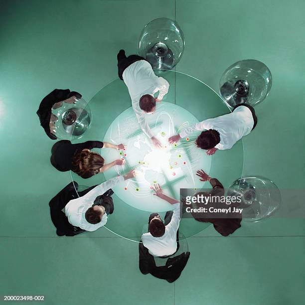 business people at table placing markers on map, overhead view - glass circle stockfoto's en -beelden