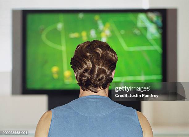 man watching sports football game on television, rear view - watching tv rear view stock pictures, royalty-free photos & images