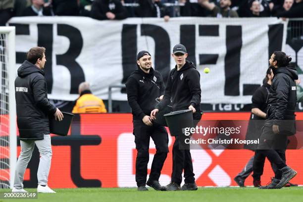 Stewards collect tennis balls after protesters throw them on the pitch during the Bundesliga match between Borussia Mönchengladbach and SV Darmstadt...