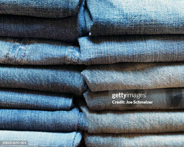 stacks of denim pants, close-up - denim photos et images de collection