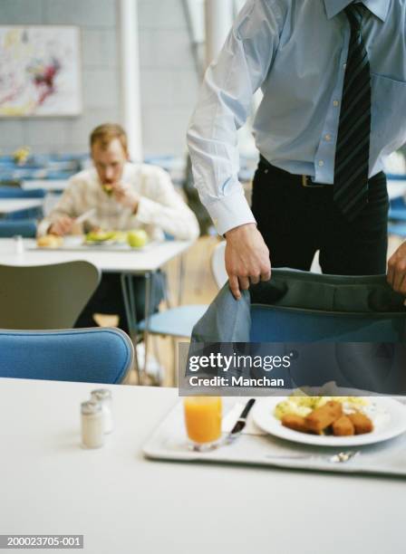 businessman in canteen putting jacket on back of chair, close-up - lunch tray stock pictures, royalty-free photos & images