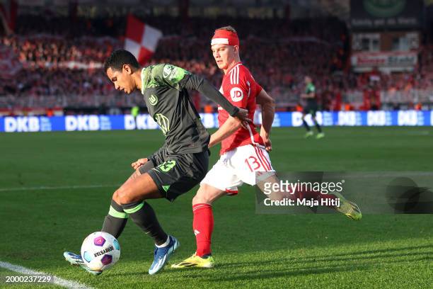 Rogerio of VfL Wolfsburg runs with the ball under pressure from Andras Schaefer of 1.FC Union Berlin during the Bundesliga match between 1. FC Union...