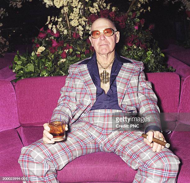 elderly man sitting on couch with cocktail and cigar, portrait - bling bling ストックフォトと画像