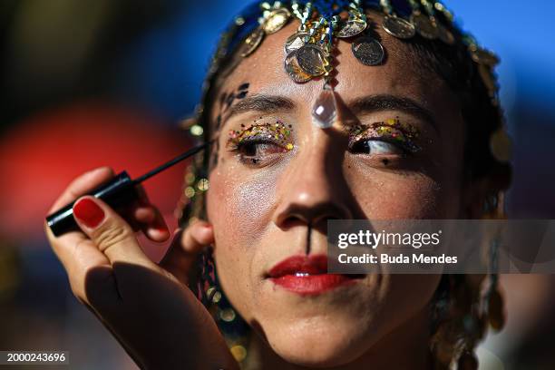 Reveller has her makeup done during the 'Amigos da Onça' street party on the second day of Carnival on February 10, 2024 in Rio de Janeiro, Brazil.