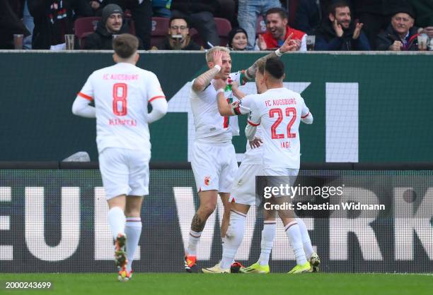 Philip Tietz of FC Augsburg celebrates scoring his team's first goal with teammate during the Bundesliga match between FC Augsburg and RB Leipzig at...