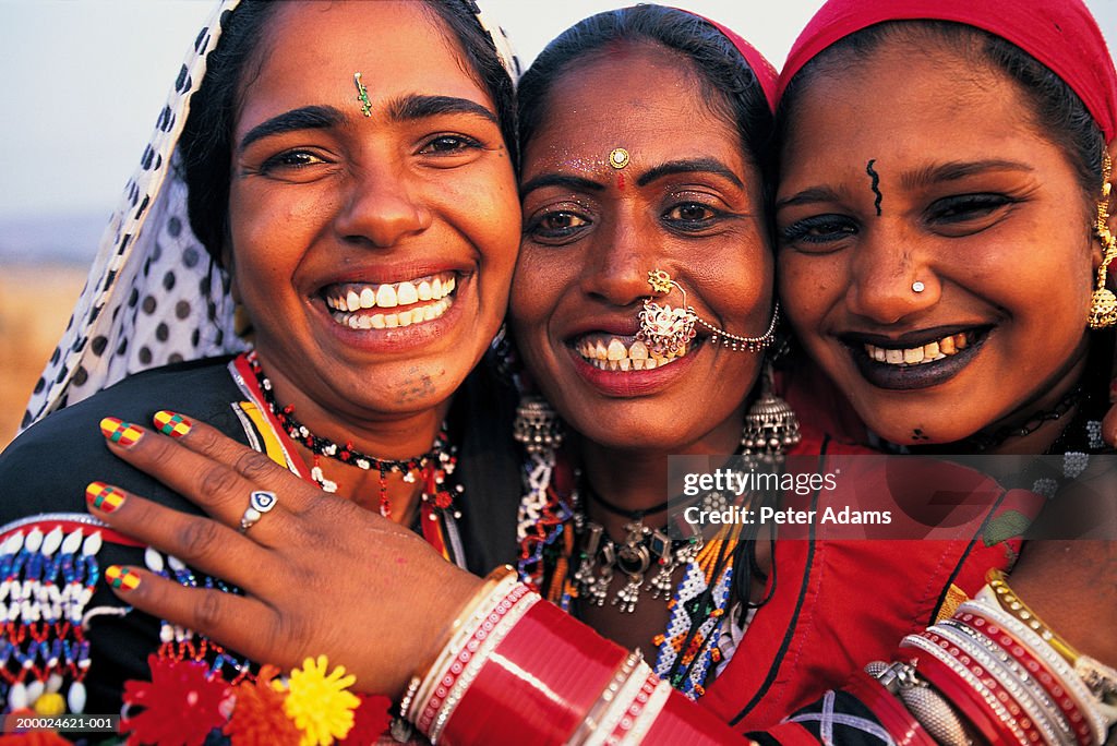 Three women embracing, smiling, portrait, close-up