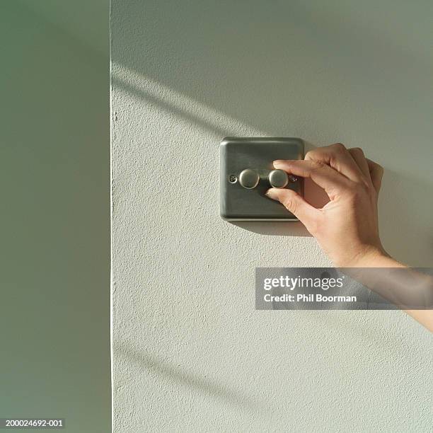 young woman adjusting dimmer switch, close-up - dimmer stock-fotos und bilder