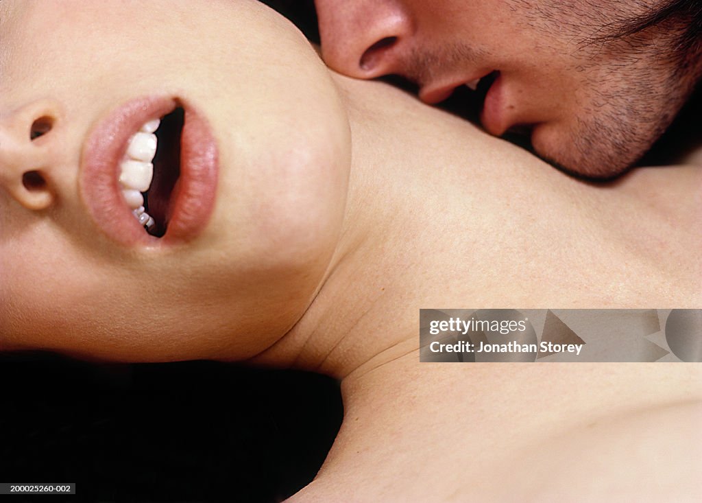 Intimate couple, man kissing woman's neck, close-up