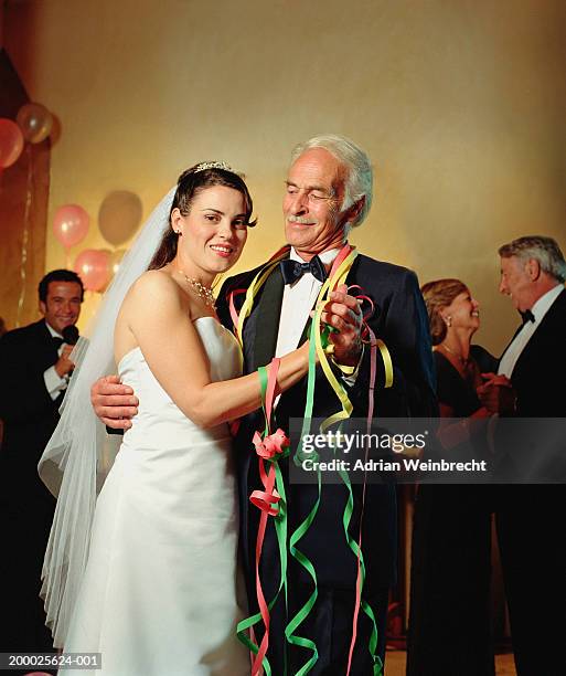 bride dancing with mature male guest at wedding reception, portrait - bride father stock-fotos und bilder